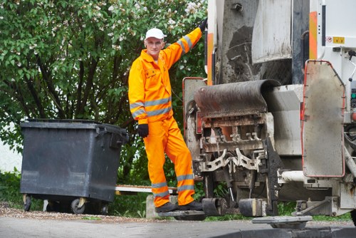 Workers loading waste into a skip in Putney